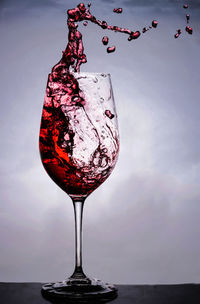 Close-up of beer glass against water against sky