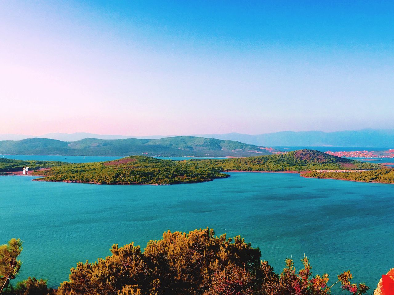 water, tranquil scene, scenics, copy space, blue, clear sky, tranquility, beauty in nature, mountain, idyllic, sea, nature, non-urban scene, mountain range, day, outdoors, calm, multi colored, no people, solitude, vibrant color, remote, seascape, treetop, ocean