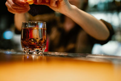 Midsection of man holding wine glass on table