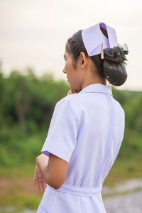 Young nurse looking away on field