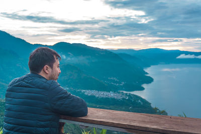 Man looking at mountains against sky