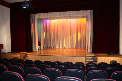 Cinema auditorium with chairs and curtains.