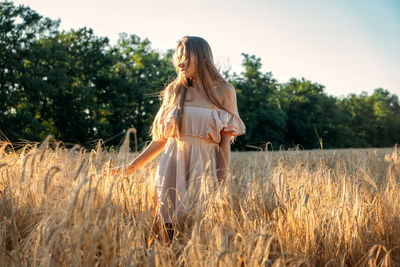 Woman standing on field against sky