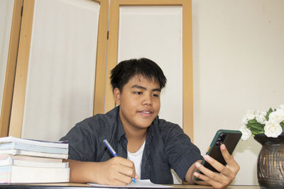 Portrait of teenage girl sitting on book