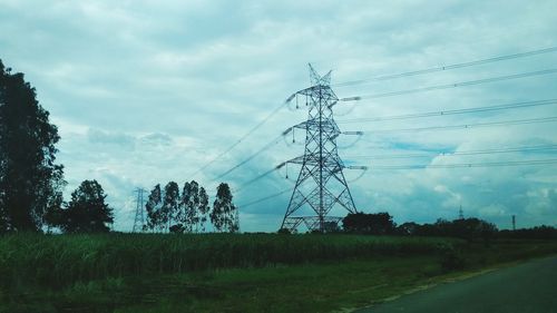 Electricity pylon on field against sky