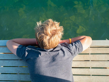 Rear view of woman sitting on bench