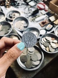 Cropped hand of woman holding old coin