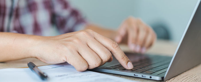 Midsection of man using laptop on table