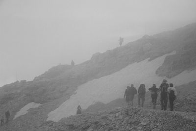 People on mountain against sky