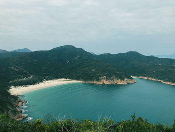 Scenic view of sea and mountains against sky