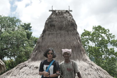 Portrait of mother and daughter against trees against sky