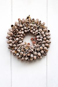 Close-up of acorns wreath on white wall