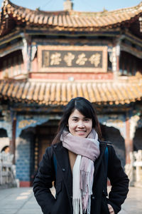 Portrait of smiling woman standing against temple