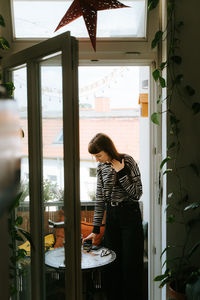 Woman standing by window