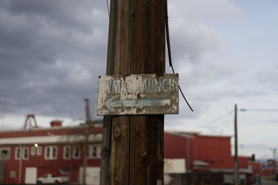 Close-up of wooden pole against cloudy sky