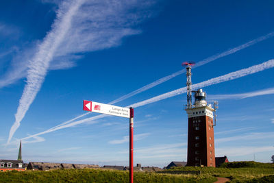 Low angle view of wind turbines on field