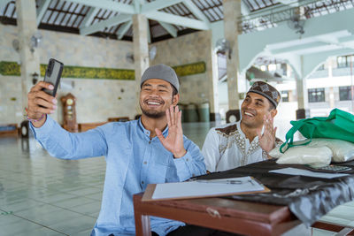 Smiling man talking on video call at mosque