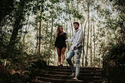 Couple walking against trees in forest