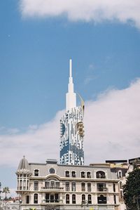 Tower of building against cloudy sky