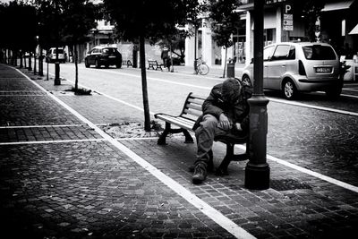 People sitting on footpath in city