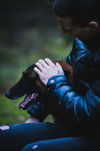 Man with dog sitting outdoors