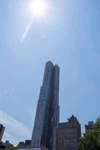 Low angle view of modern buildings against blue sky