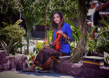 Portrait of smiling girl sitting outdoors