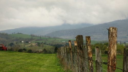 Scenic view of field against cloudy sky