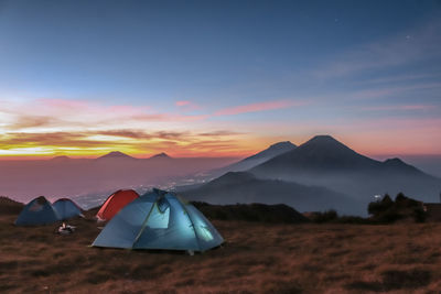 Tent on field against sky during sunset