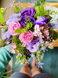 Low section of person standing by purple flowering plants