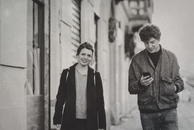 Young couple walking on street in city