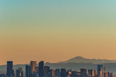 Silhouette buildings against clear sky during sunset