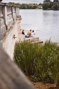 Couple sitting on grass by water