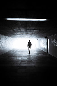 Rear view of silhouette man walking in subway