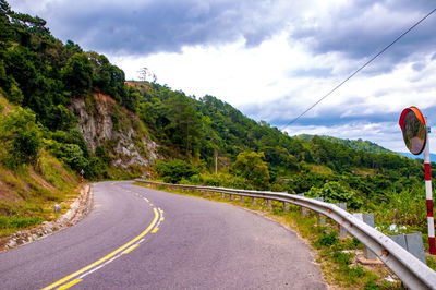 Road leading towards mountain against sky