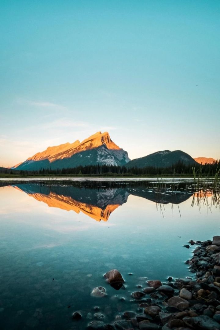 reflection, water, sky, sea, scenics - nature, beauty in nature, dawn, nature, mountain, horizon, morning, tranquility, sunrise, environment, landscape, tranquil scene, travel destinations, shore, no people, coast, land, ocean, blue, travel, bay, outdoors, lagoon, sunlight, clear sky, non-urban scene, copy space, rock, body of water, idyllic, tourism, cloud