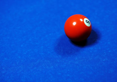 High angle view of number 5 pool ball on blue table