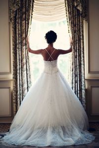 Rear view of bride standing by window