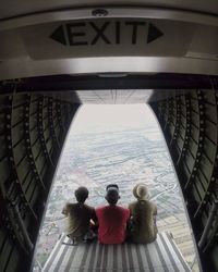 Rear view of people sitting in corridor