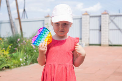 Portrait of smiling girl standing against built structure