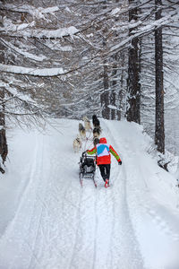 Rear view of people on snow covered field