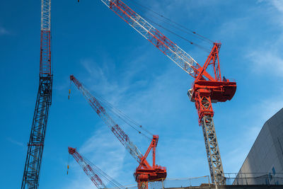 On a construction site there are several lifting cranes.