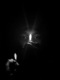 Close-up of lit candle in darkroom