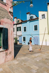 Woman standing by window of building