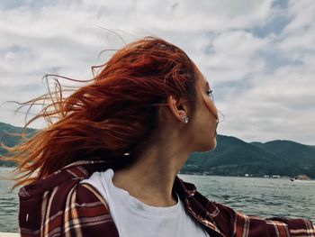 Close-up of woman at beach against sky