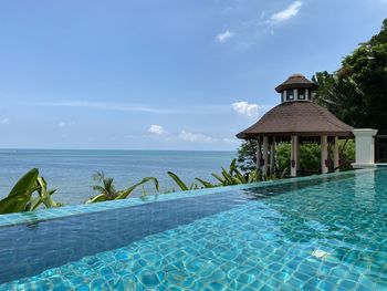 View of swimming pool by sea against sky