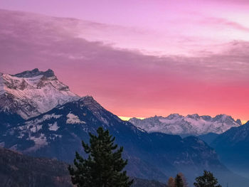 Scenic view of snowcapped mountains against sky during sunset