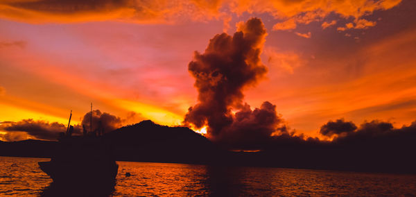 Scenic view of sea against dramatic sky during sunset