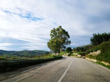 Road amidst trees against sky