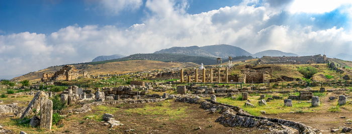 Panoramic view of old ruins against cloudy sky